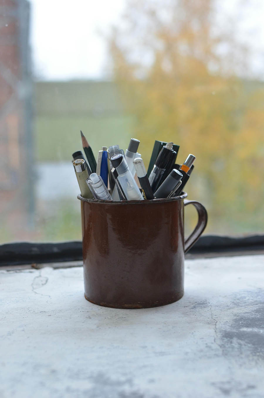 cup holding pens and markers acts as a still life for a drawing exercise.